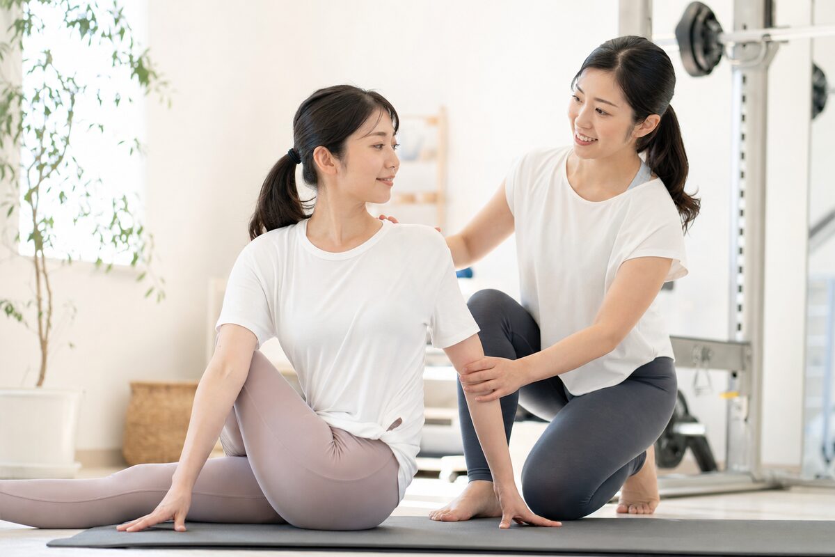 女性専用パーソナルジムでトレーナーの指導を受ける女性